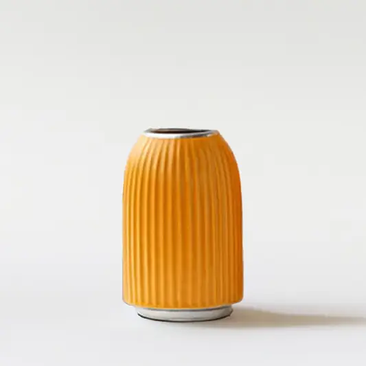 Mustard yellow ribbed ceramic decorative vase with rounded form for shelf styling and modern home decor displays.