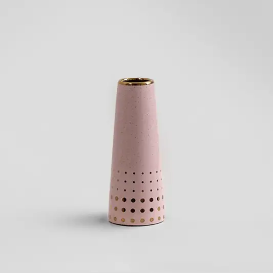 Blush pink ceramic decorative vase with perforated texture and gold rim for tabletop styling and modern home decor.