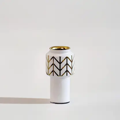 White ceramic decorative vase with black geometric pattern and gold rim for elegant contemporary home decor styling.