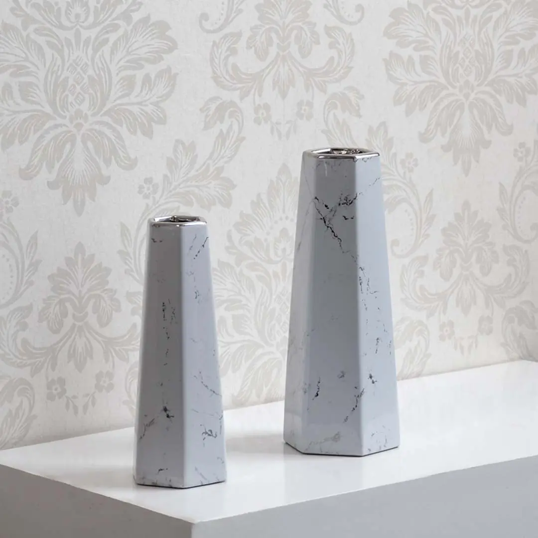 Collection of modern white marble ceramic vases with geometric design ideal for tabletop decor and flower display.