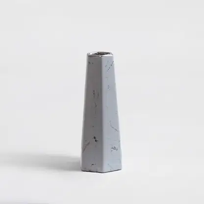 Tapered hexagonal ceramic vase with a light grey marble texture and dark speckles on white background for modern styling.