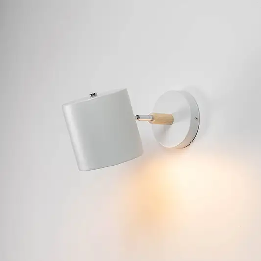 A modern lantern shown on a white background with the inner candle light on creating a warm glow that highlights the clear glass panels and smooth matte finish of the frame.