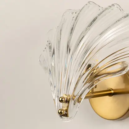 Elegant brass wall light with textured crystal glass shade for luxury modern interior wall decor.