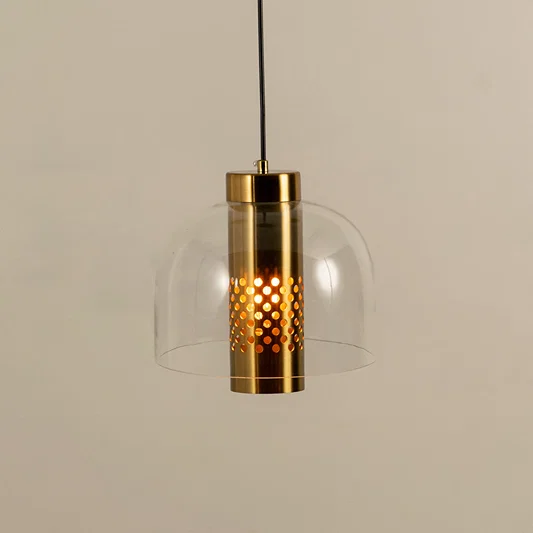 Closeup of pendant light with gold metal holder and clear glass shade showcasing warm light and premium design for interior decor.