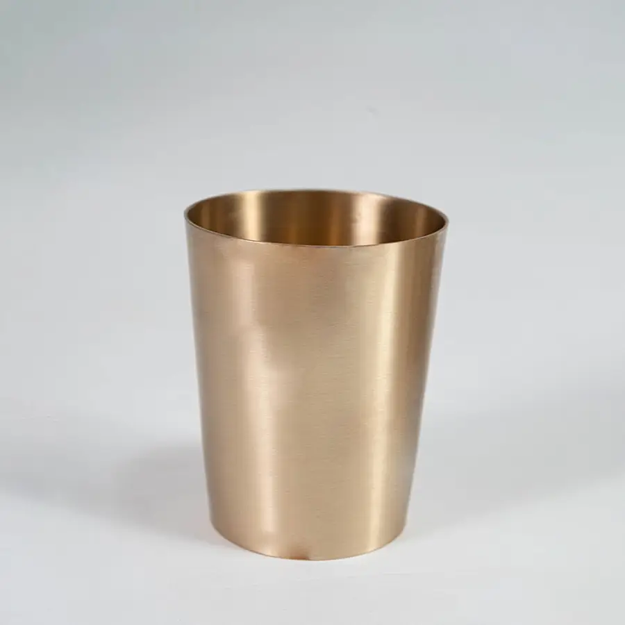 A brass cup shown on a white background highlighting its smooth metallic finish and simple cylindrical shape designed for everyday serving use.