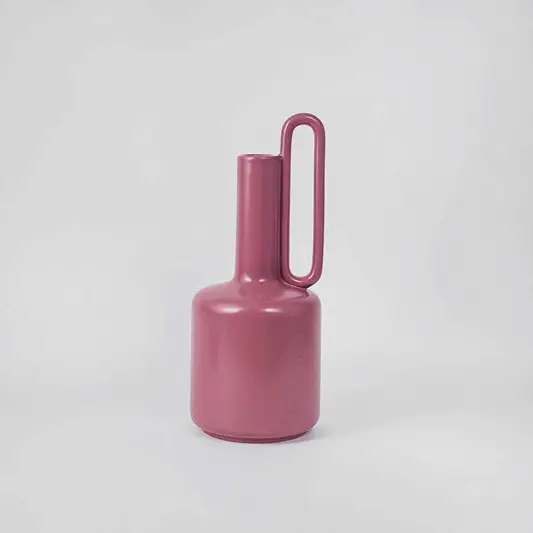 Modern glossy magenta pink ceramic jug vase with single high handle on clean white background for chic colorful decor.