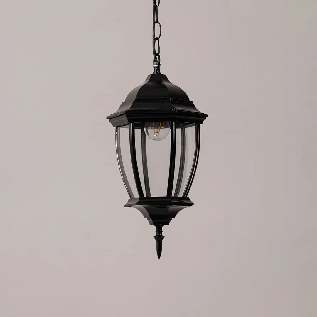 Contemporary black metal hanging lantern light with clear curved glass for stylish outdoor decor.