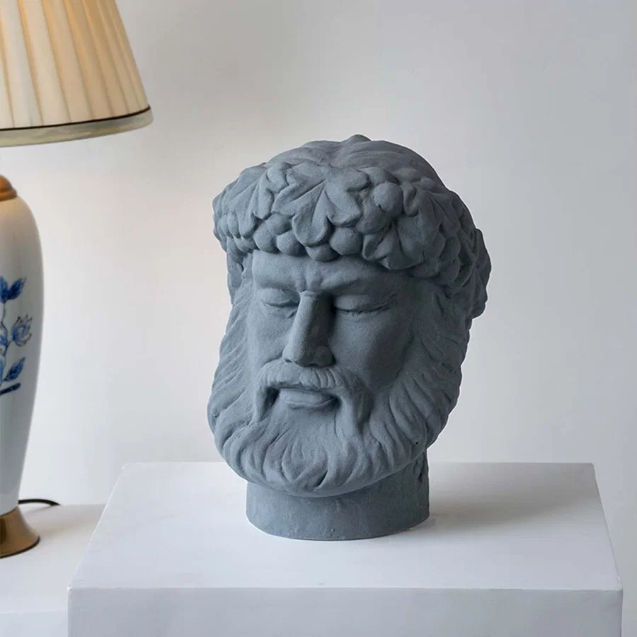 Gray stone sculpture head displayed on a simple table adding an artistic décor accent that enhances interior styling with sculptural charm and refined detail.