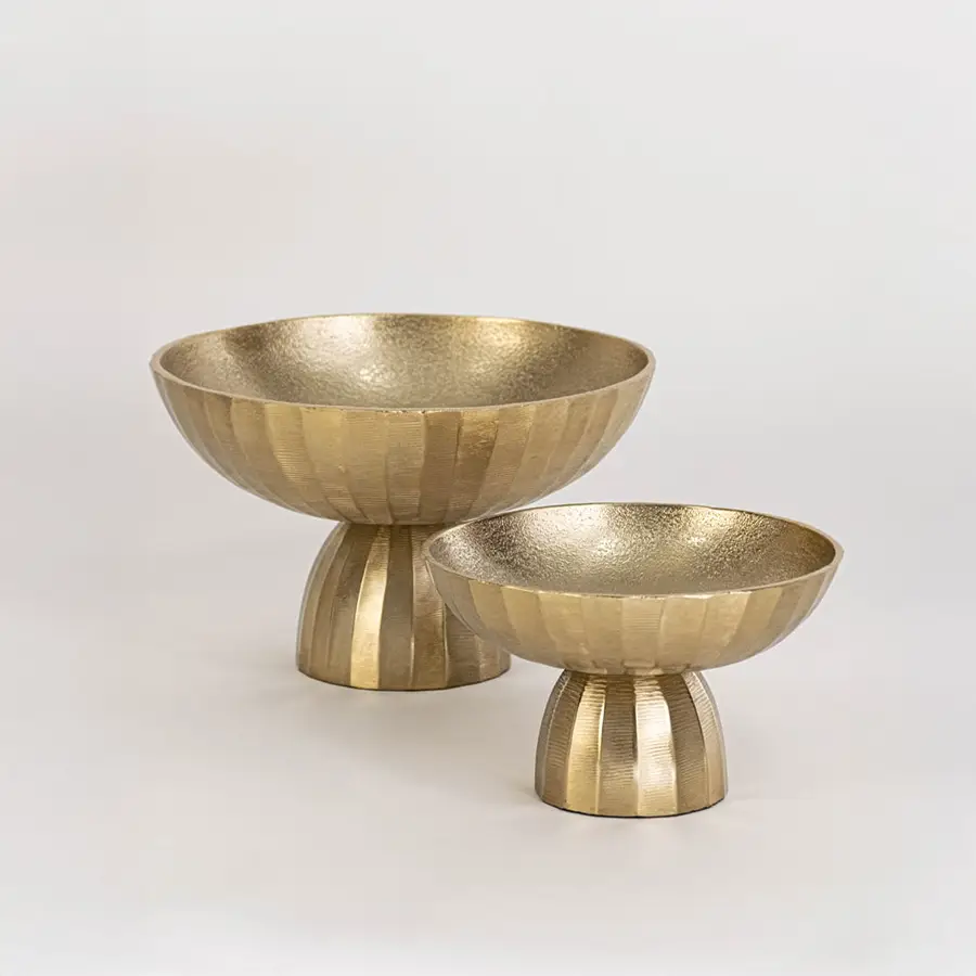 Gold textured pedestal bowl shown as part of a grouped display on a clean white background highlighting its modern design