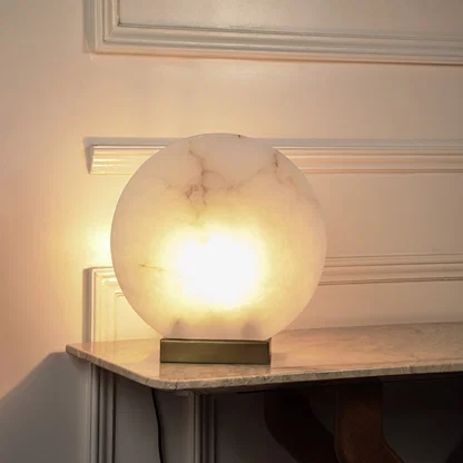 Modern alabaster style table lamp with illuminated stone globe and black base for sophisticated home ambiance.