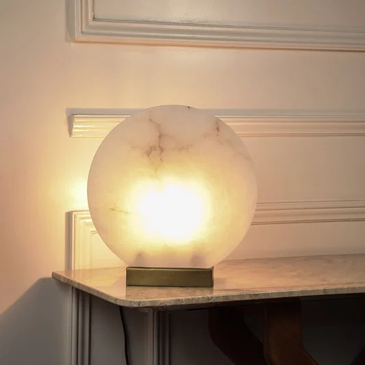 Modern alabaster style table lamp with illuminated stone globe and black base for sophisticated home ambiance.