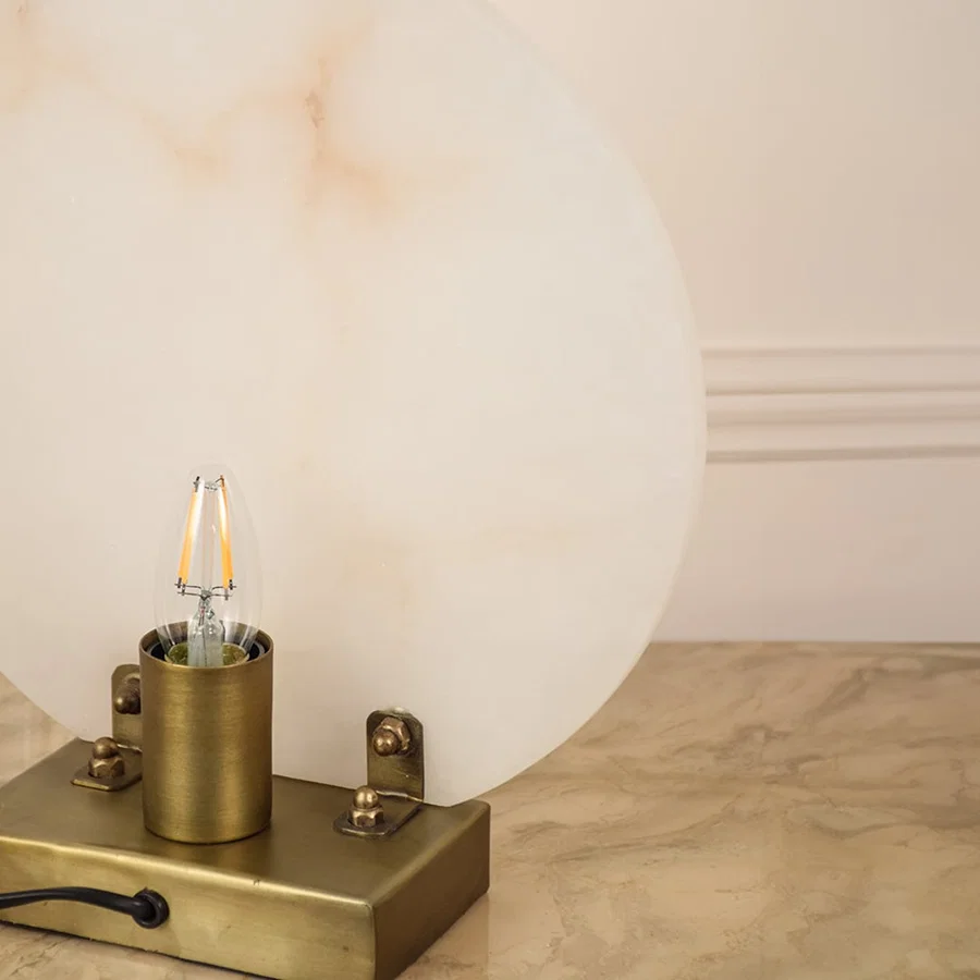 Closeup of marble table lamp showing smooth natural veining and polished metal base emphasizing craftsmanship and premium design.