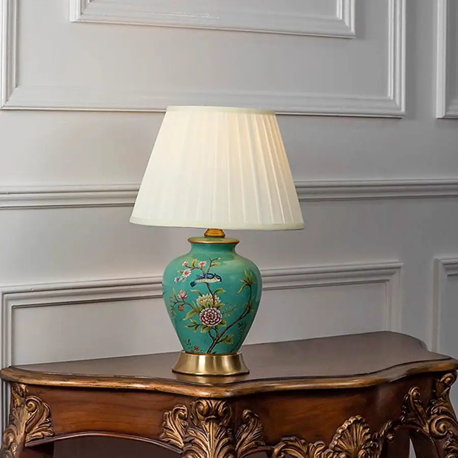 Table lamp with green ceramic base and white pleated shade on wooden console table classic decorative lighting for living room decor.