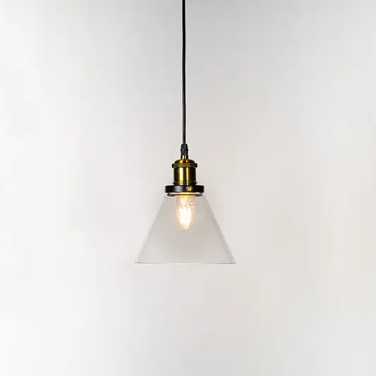 Amber glass globe pendant light illuminated with warm glow and brass metal accents for stylish ceiling lighting decor.