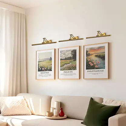 Gold picture light enhancing artwork in a modern interior bringing warm focused lighting to living room and hallway wall decor.