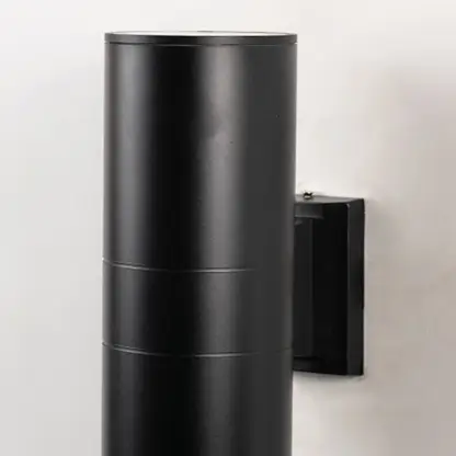 Closeup of tall black metal cylindrical outdoor wall light showing smooth matte finish and modern exterior design.