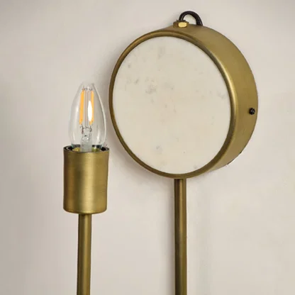 Closeup of marble and gold metal wall light for stylish bedroom and premium decor styling spaces.

