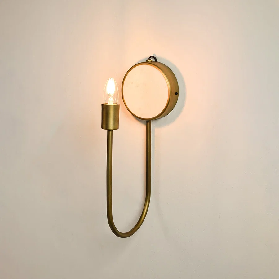 Modern marble and gold metal wall light with warm glow for elegant hallway and luxury decor spaces.