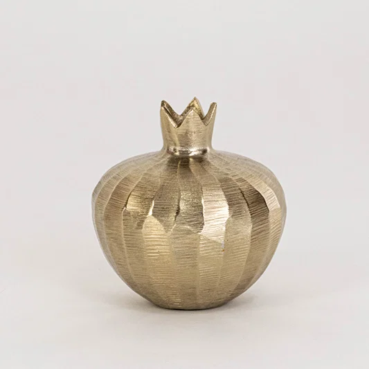 Decorative metal storage bowl in gold finish with crown lid for table decor or shelf styling modern home placement white background.