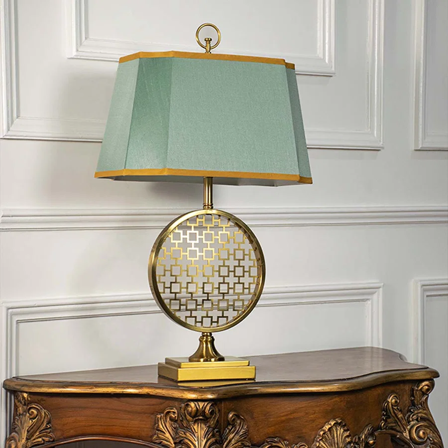 Green shade gold frame table lamp on carved console table with light off for artistic decorative home décor.