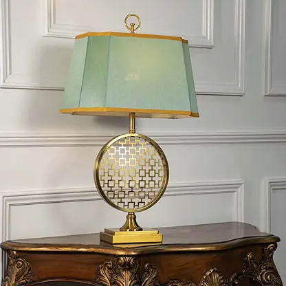 Green shade gold and white patterned table lamp on carved console table with light off for artistic decorative décor.