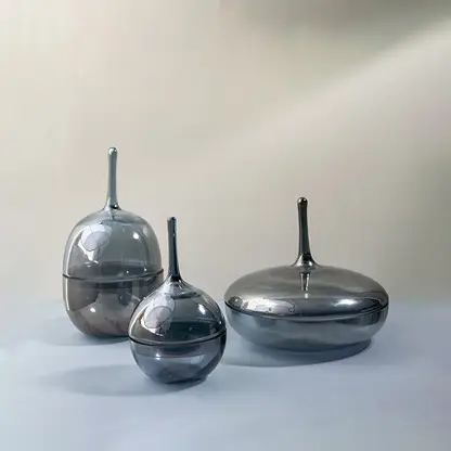 Set of glossy grey glass jars in different sizes styled together as modern decorative accents for chic interiors.