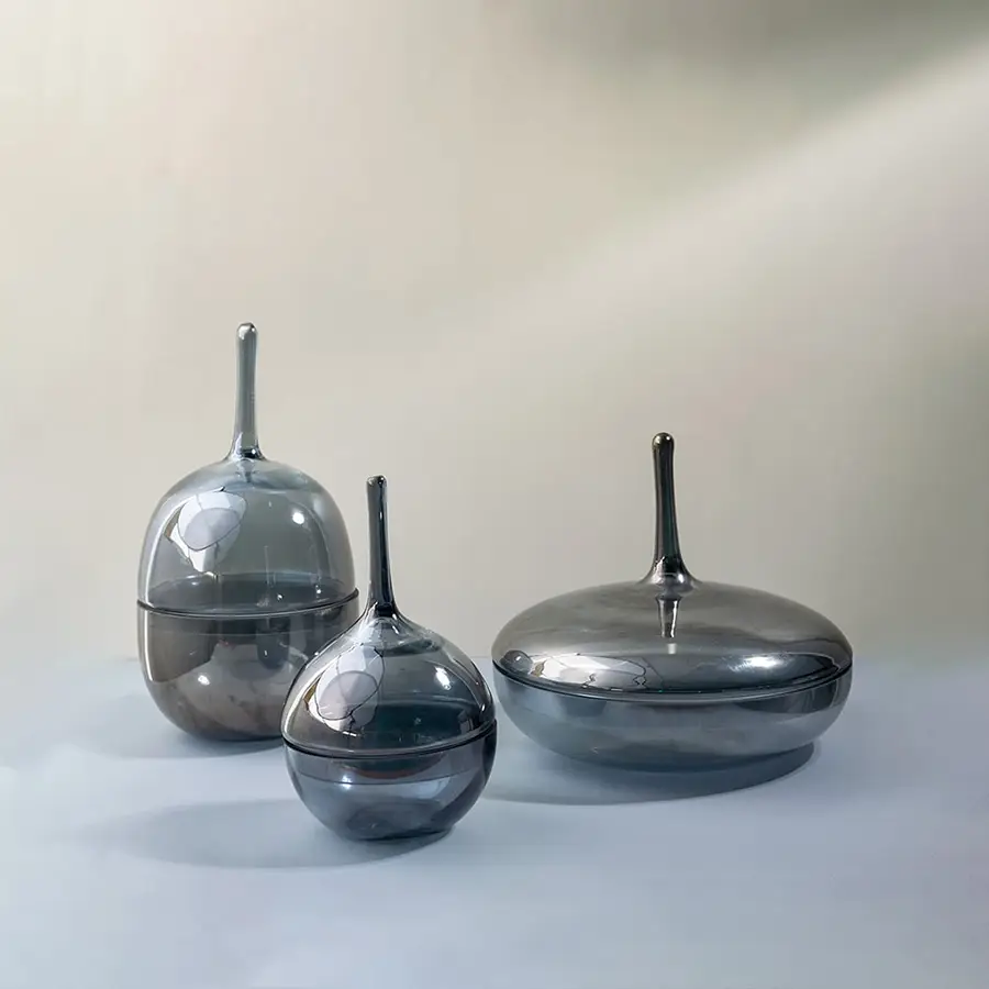 Set of glossy grey glass jars in different sizes styled together as modern decorative accents for chic interiors.