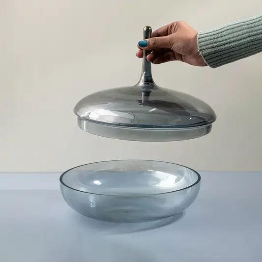 Clear glass decorative bowl with matching lid displayed for elegant tabletop styling and modern home decor.
