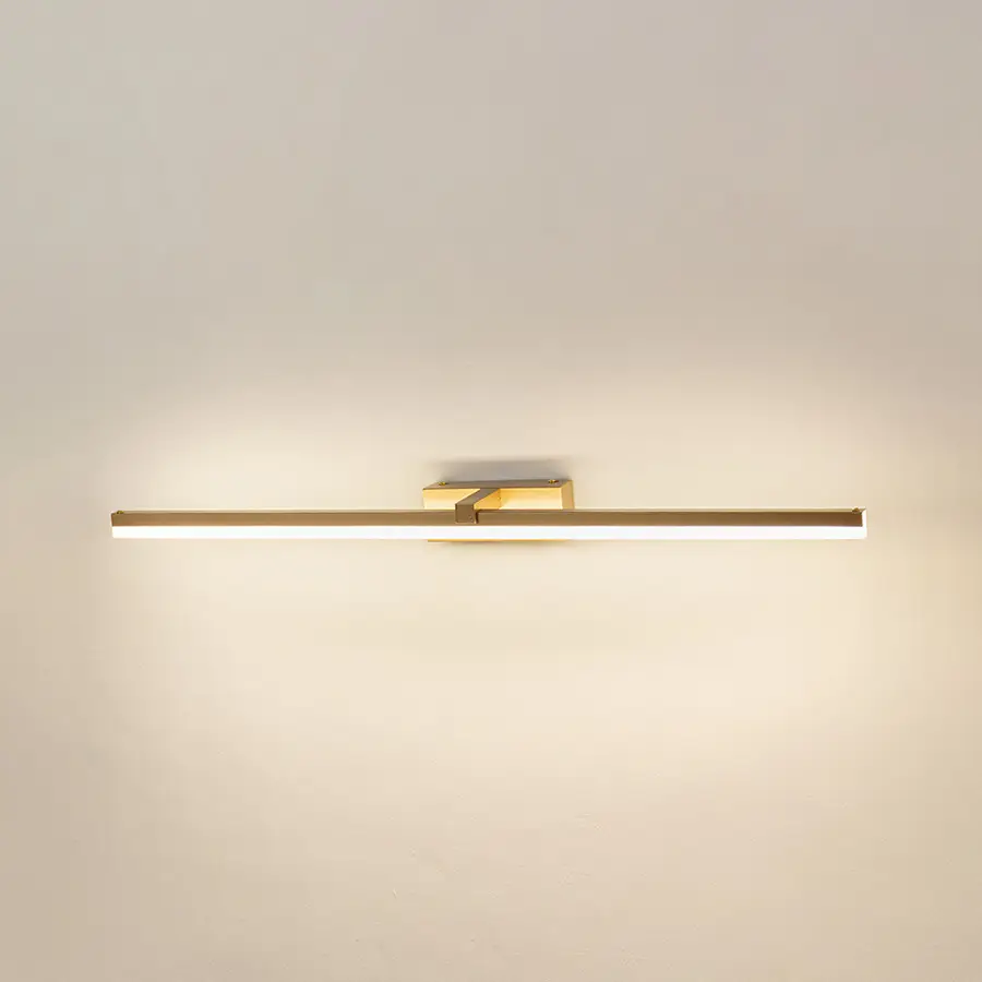 Modern wall light in gold metal finish with linear bar design for bathroom or vanity decor lighting white background.