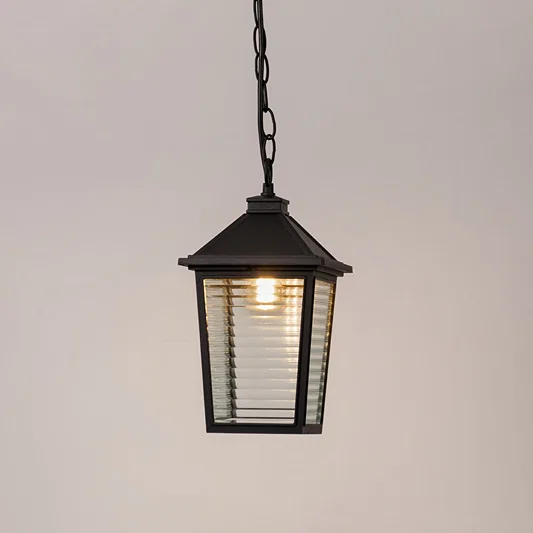 Contemporary outdoor pendant light in black metal with ribbed glass panels for entrance or patio decor lighting white background.