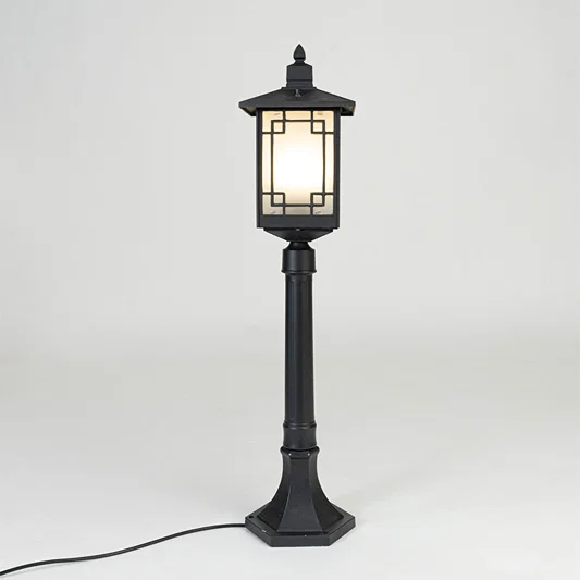 Vintage black outdoor garden light with warm glowing panels for elegant exterior decor styling use.