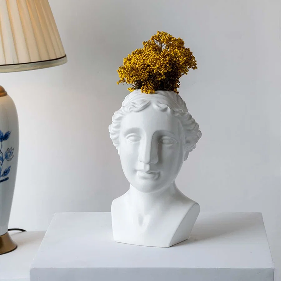 Artistic white bust sculpture placed on a minimal stepped setup adding a modern gallery inspired decorative touch to contemporary interiors.