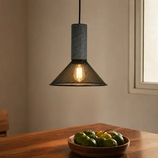 Industrial grey textured stone and black mesh cone pendant light hanging above a wooden dining table for contemporary kitchen styling.
