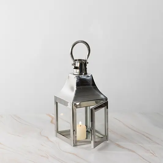Stainless steel lantern with candle lit displayed on white background for modern home and garden decor.