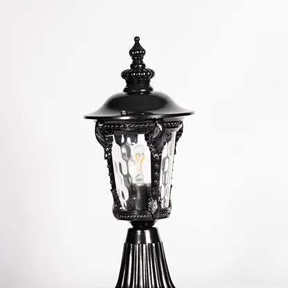 Closeup of black pillar light showing ornate frame design and patterned clear glass for stylish vintage outdoor lighting.