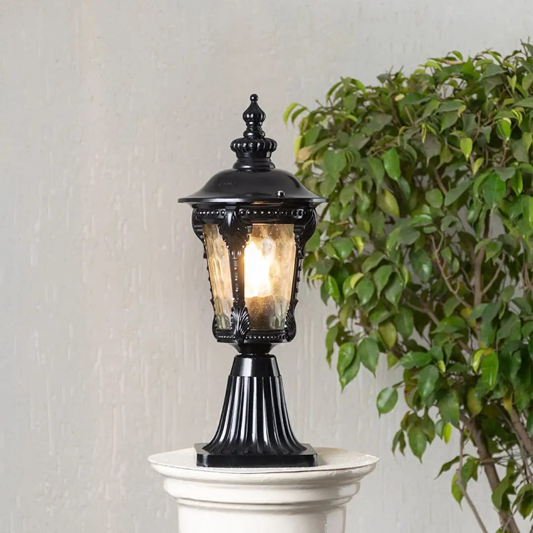 Black pillar light with decorative patterned glass displayed on white background highlighting elegant classic outdoor design.