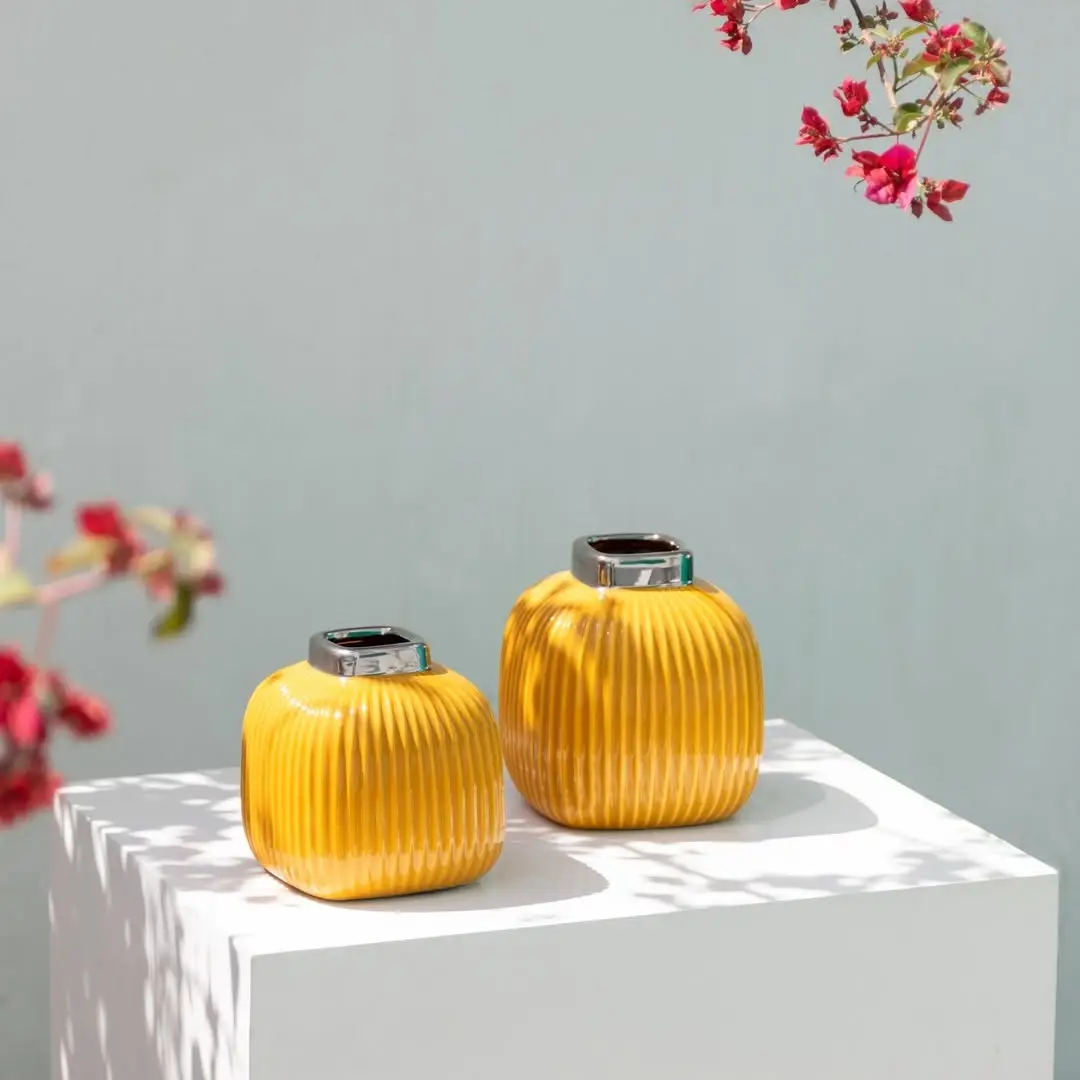 Yellow ceramic ribbed mini vase styled in a soft neutral scene adding a bright modern touch to tabletop home decor.
