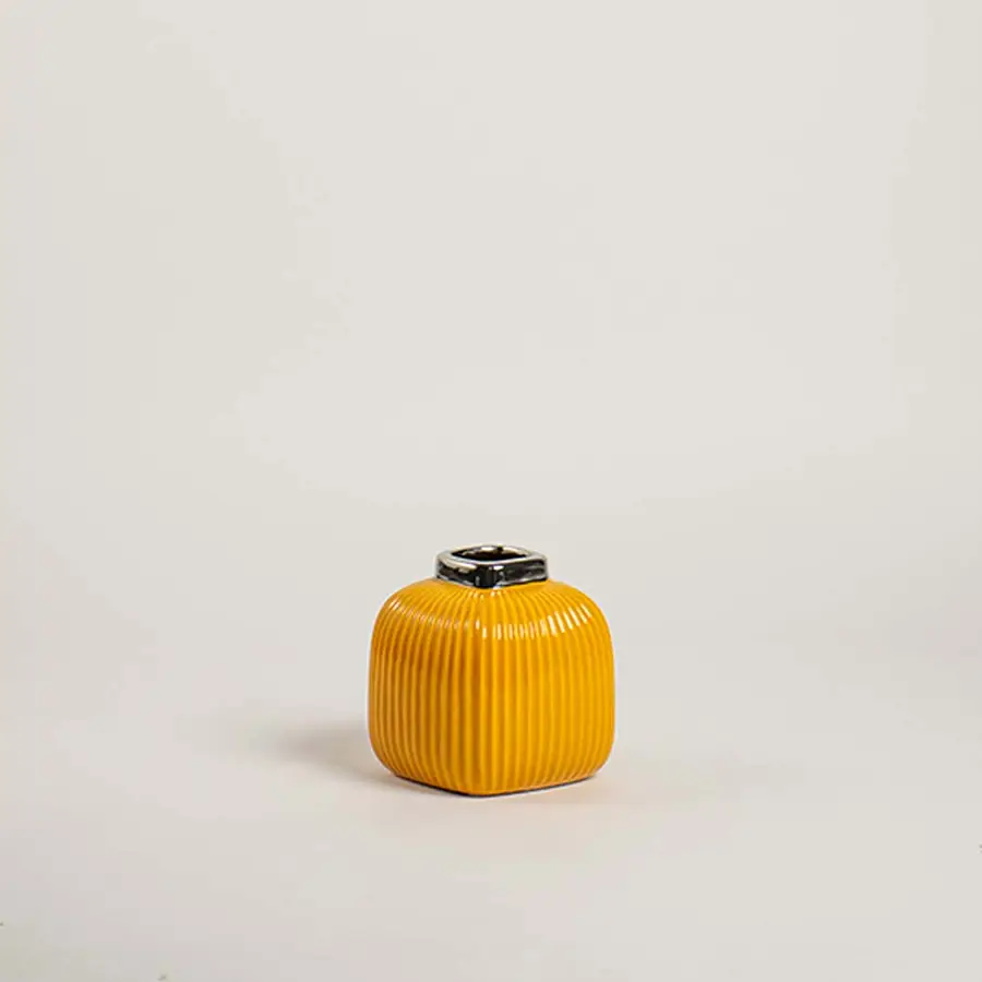 Mustard yellow ribbed cube ceramic mini vase with a metallic silver collar rim on white background for vibrant modern art.