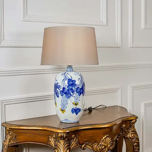 Blue floral ceramic table lamp with fabric shade crafted for elegant traditional decor and ambient table lighting indoors.