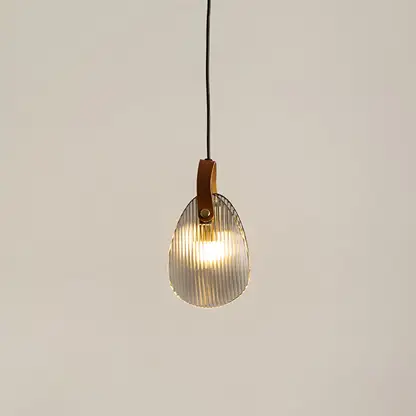 Amber glass pendant light illuminated to display elegant modern ceiling lighting with warm decorative styling.