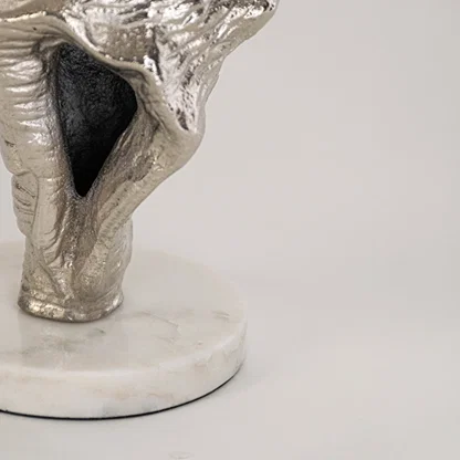 Closeup of silver conch shell decor showing intricate marine texture and round white base for a refined accent.