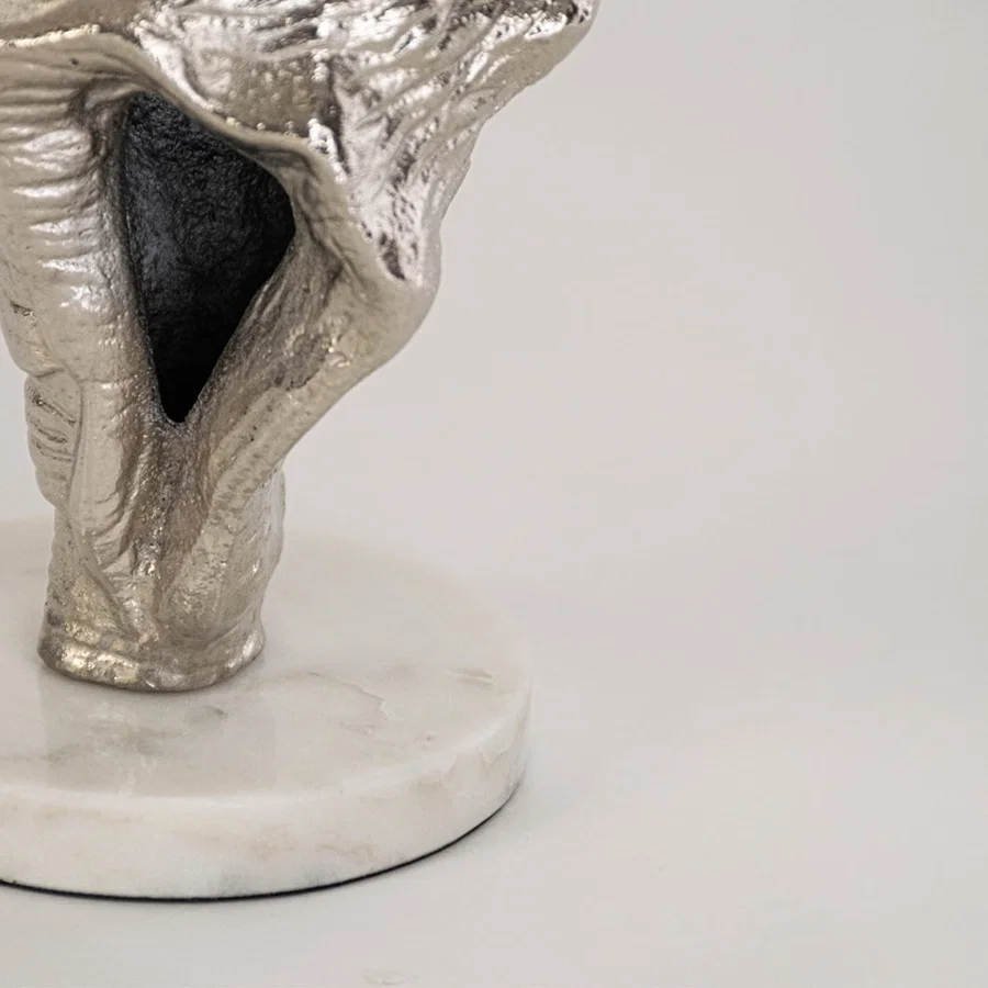 Closeup of silver conch shell decor showing intricate marine texture and round white base for a refined accent.