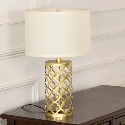 White shade gold geometric lamp on wooden table with light on and white wall background for chic modern décor.