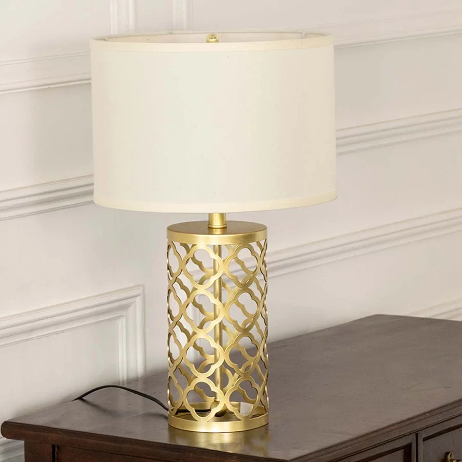 White shade gold geometric lamp on wooden table with light on and white wall background for chic modern décor.