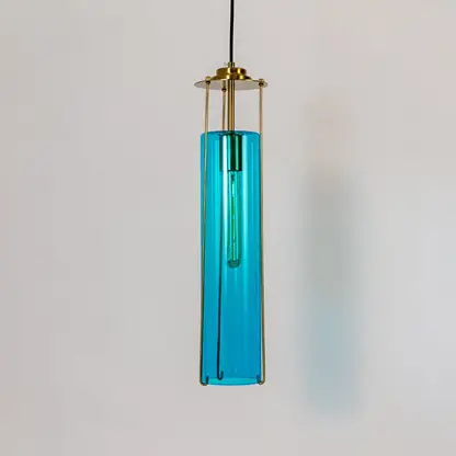 Blue glass pendant light with gold metal fixture illuminated to showcase luxury decorative ceiling lighting.