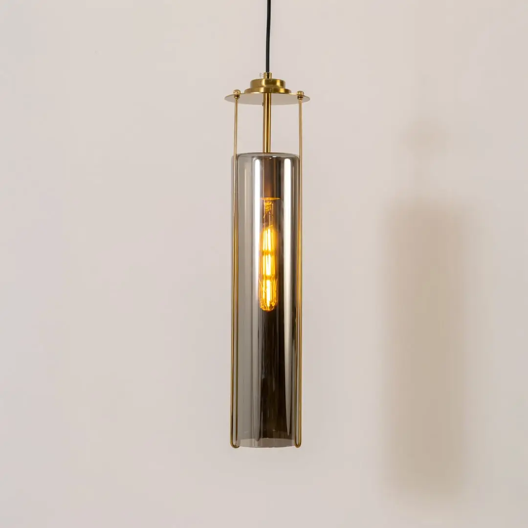Smoke glass pendant light with gold metal fixture illuminated to display contemporary decorative ceiling lighting.
