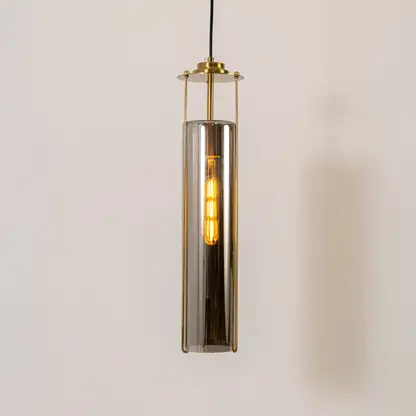 Smoke glass pendant light with gold metal fixture illuminated to display contemporary decorative ceiling lighting.