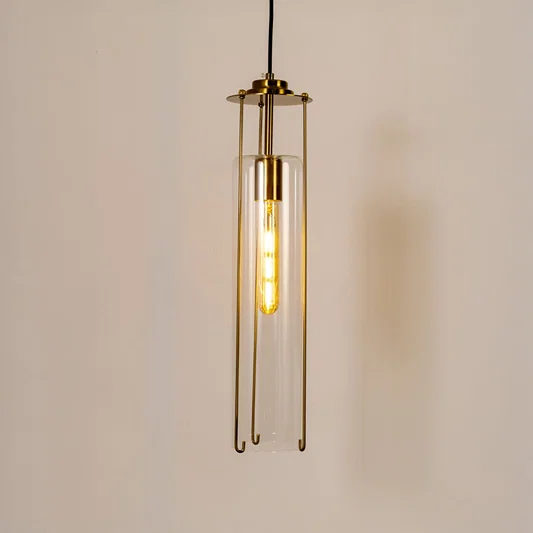 Clear glass pendant light with gold metal fixture illuminated to showcase refined modern ceiling lighting.