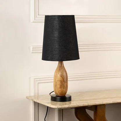 Black fabric shade table lamp with sculpted natural wood base for elegant bedside and living room decor styling.
