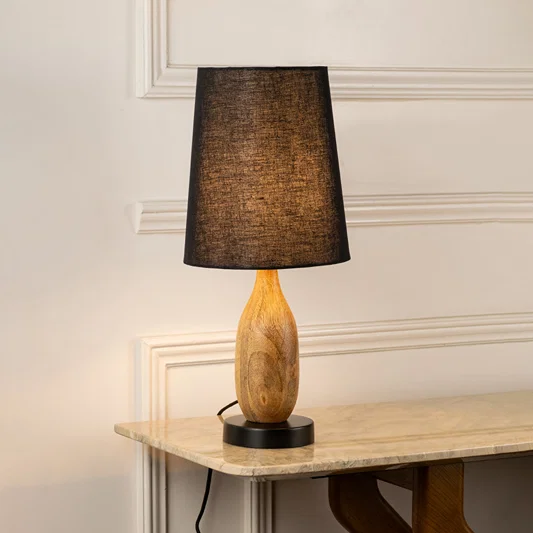 Table lamp with dark fabric shade and wooden base perfect for warm bedroom or living room table decor placement on clean background.